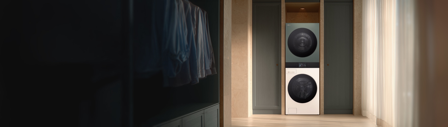 어두운 톤의 실내 공간에 중앙 수납장 안에 LG전자 트롬 워시타워가 설치되어 있고, 좌측에는 걸려있는 셔츠들이, 우측에는 흰색 커튼이 드리워진 창가가 보인다.